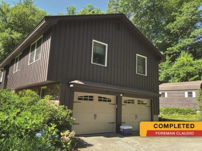dark brown house with light beige garage doors