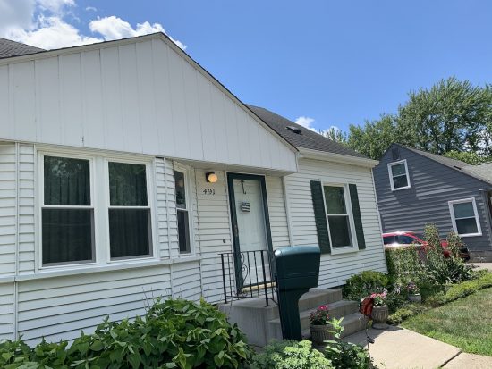 A home exterior that was painted white with black shutters.