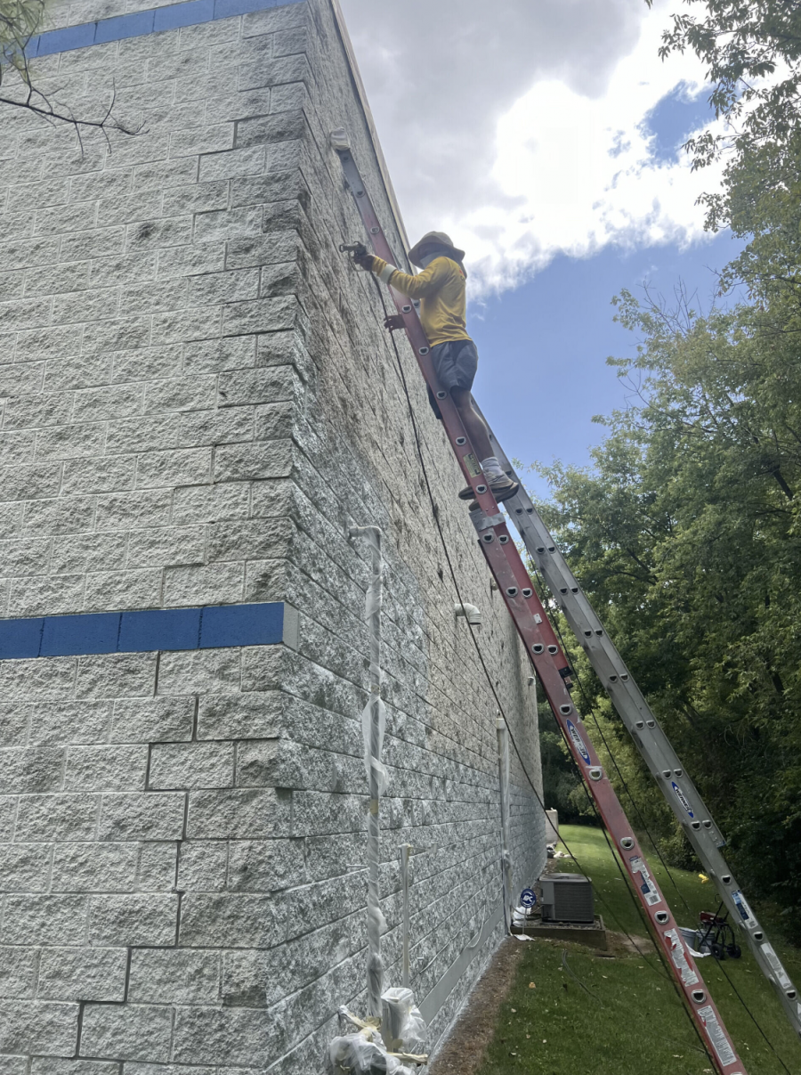 painter on ladder against commercial building exterior Preview Image 3