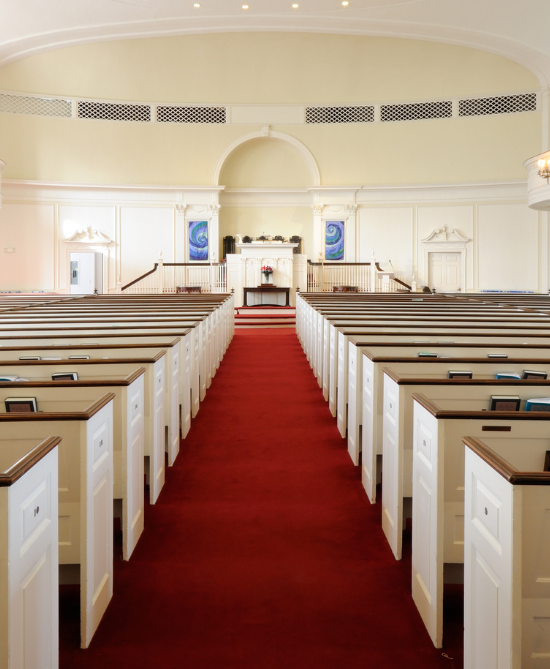 church with white and brown church pews and red carpeted aisle