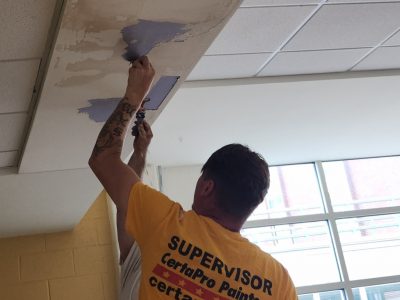 painter repairing cafeteria ceiling