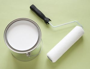 white paint in can and paint brush