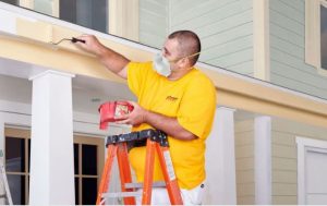 man painting exterior of a home