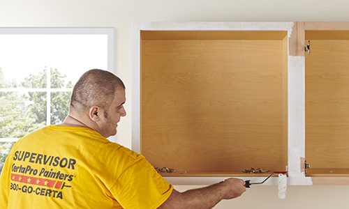 Worker painting cabinets