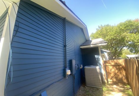 side of house with dark blue painted siding