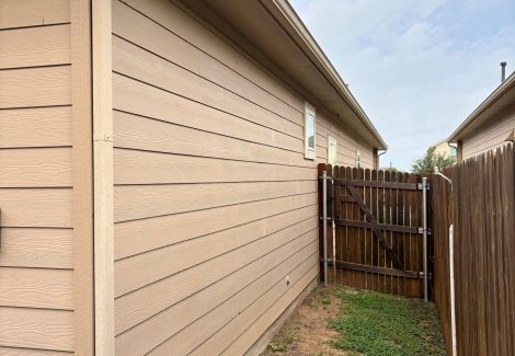 side of house with wooden fence attached