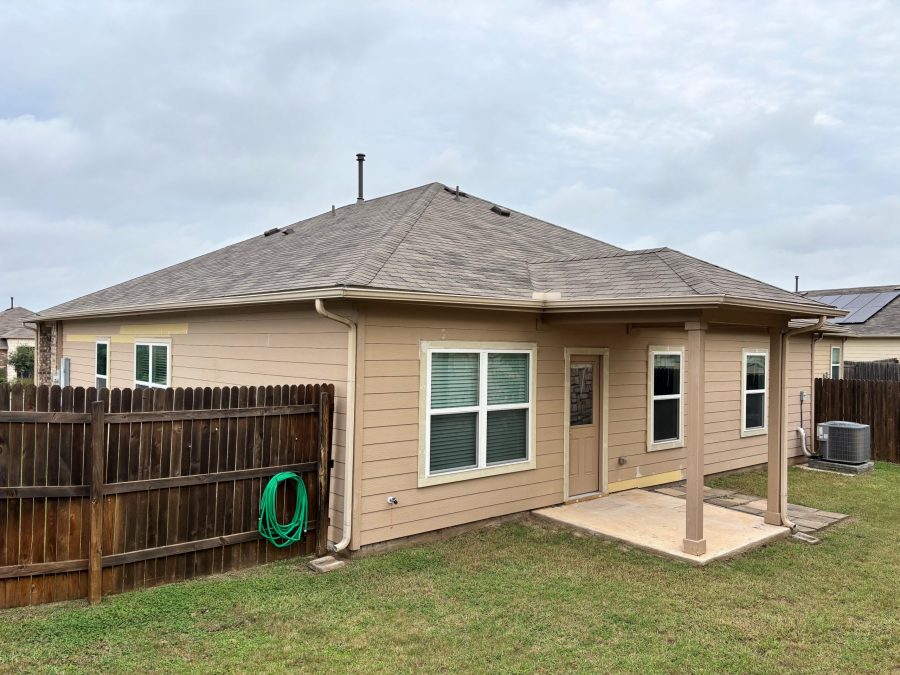 rear of tan house with covered doorway and wooden fence attached Preview Image 9