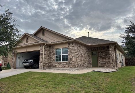 front corner of house with stone and tan siding