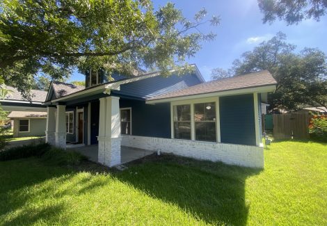 front corner of blue house with white trim and covered front porch