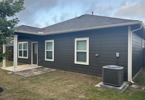 rear corner of house with charcoal painted siding