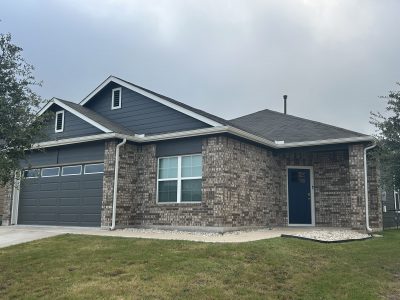 front corner of house with stone and charcoal painted siding