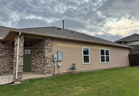 front corner of house with stone and tan siding