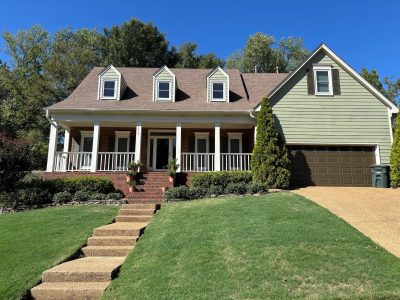 house with brick and green siding exterior