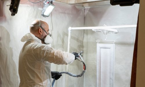 painter spray painting cabinets