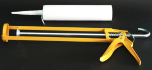 Yellow caulk gun with white caulk tube