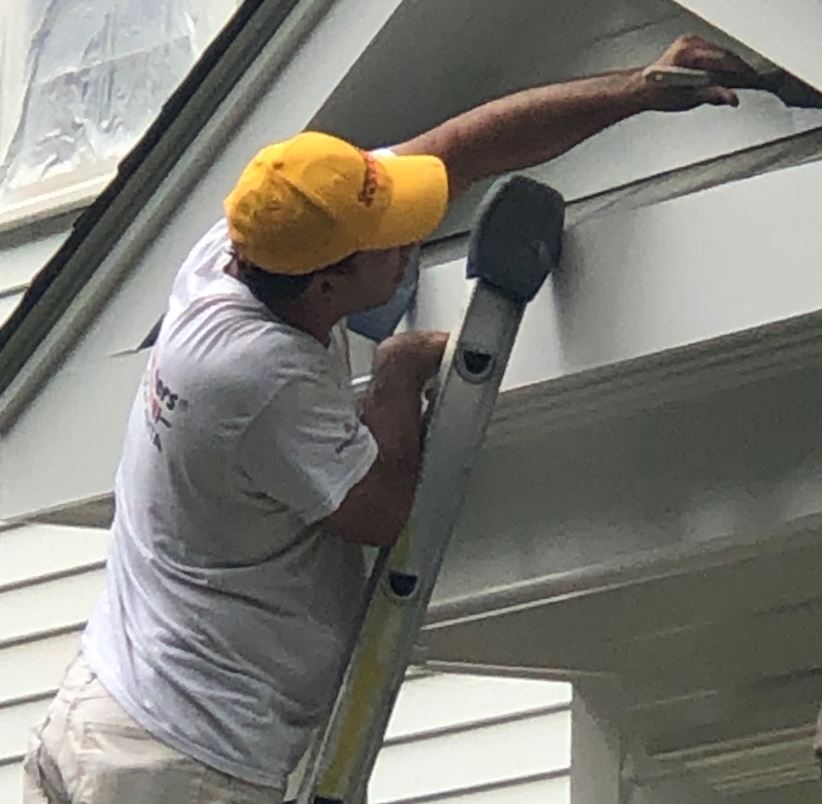 Trim and parts of the house that weren’t sprayed are painted with a brush.