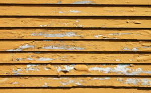 Peeling paint on yellow siding