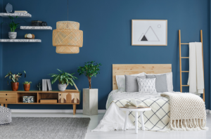Blue bedroom wall with shelving and bed