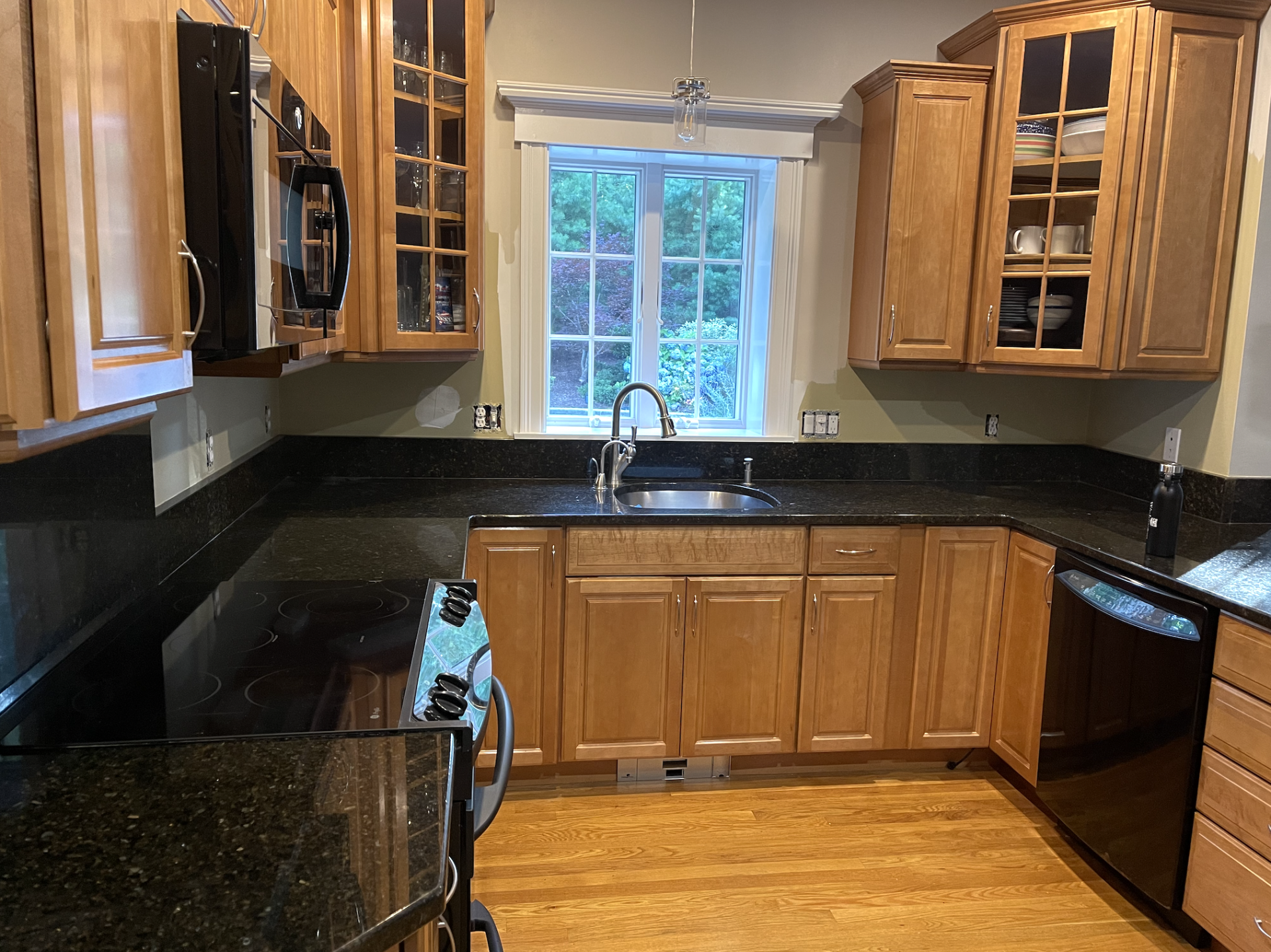 Cherry cabinets with black granite counter in kitchen