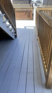 Wood railing stained on gray deck
