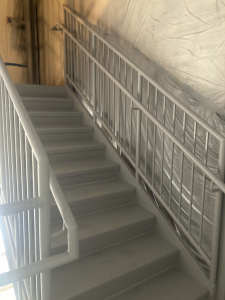 Metal railings inside of stairwell that are freshly painted gray