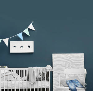 Dark teal walls in baby nursery with white furniture