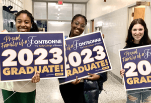 Women holding graduation signs for Fontbonne Academy in Milton