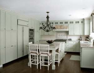 Light mint green kitchen with white table and backsplash