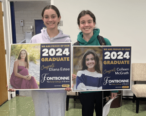 Two teenage young ladies holding their Fontbonne Graduation Signs