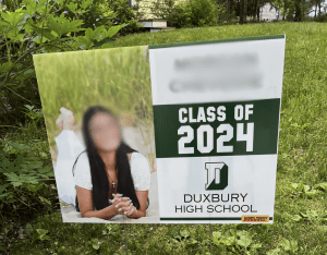 Photo of young lady on a 2024 graduation sign for Duxbury High School