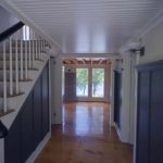 Hallway and stairs with white trim and dark blue wainscot