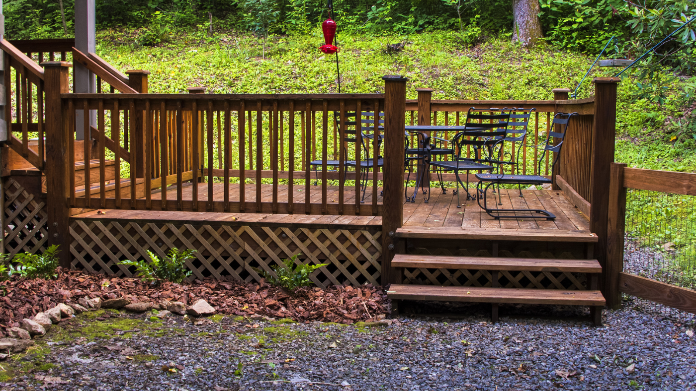 Deck near woods with lattice on bottom