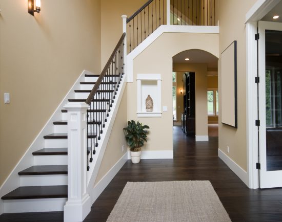 Staircase showing beige walls and a black bannister