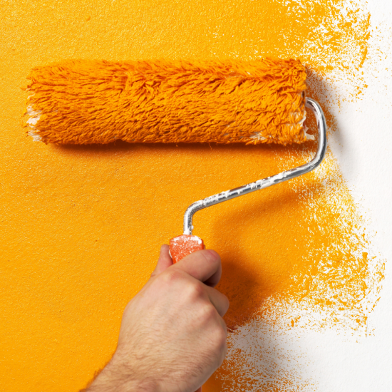 yellow paint roller painting a wall