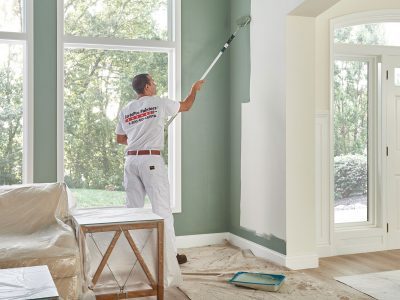 certapro employee painting interior wall with green paint