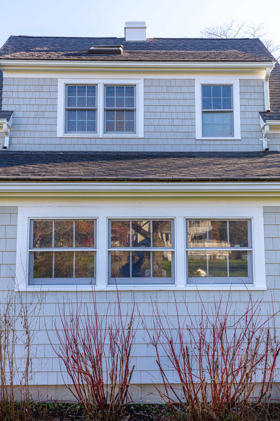 View of dormer windows and gray stained cedar shingles on home in Duxbury, MA Preview Image 5