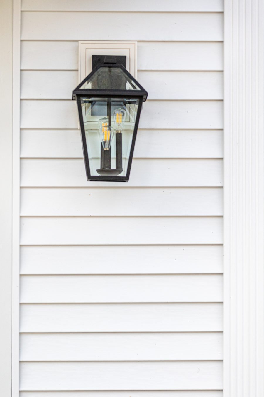 Close view of decorative lamp on white painted home. Preview Image 6