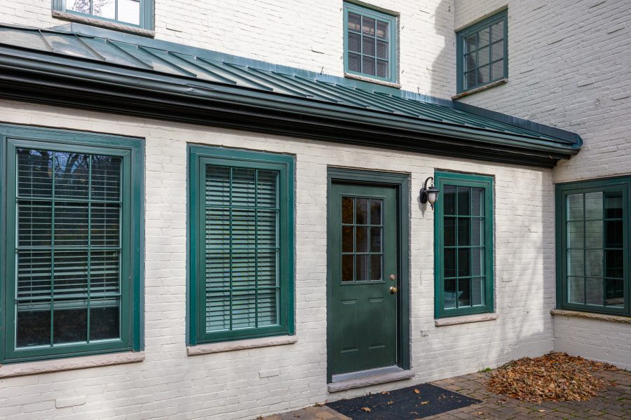 green door and window trim on white brick home Preview Image 3
