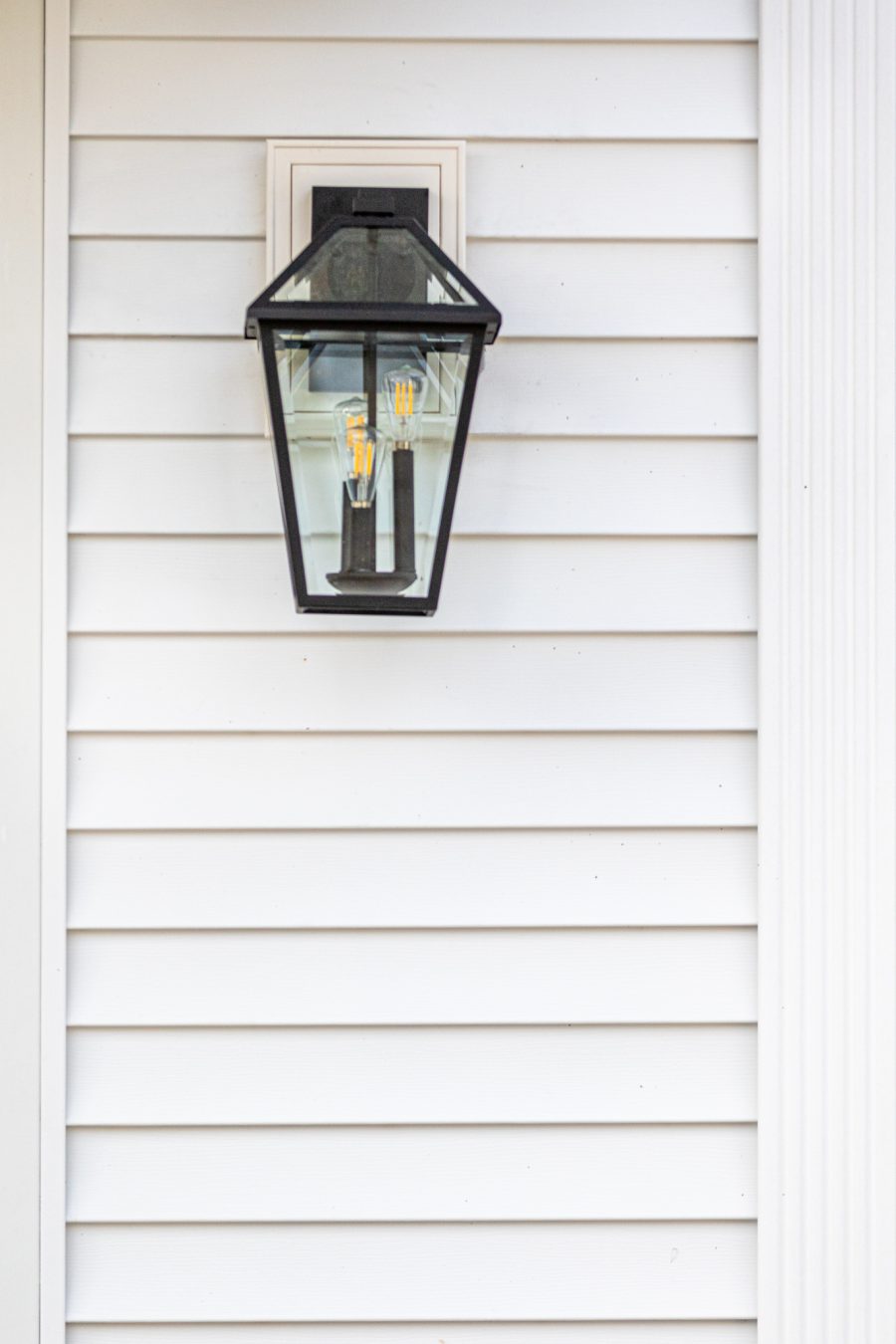 Close view of decorative lamp on white painted home. Preview Image 7
