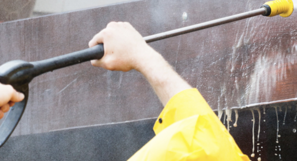 Powerwasher reaching up to wash a deck in Dartmouth MA