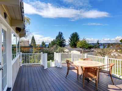 Dark stained deck overlooking trees and ocean in far background