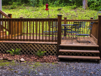 Deck near woods with lattice on bottom