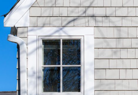 Close up view of painted roof trim, and stained cedar shingle siding