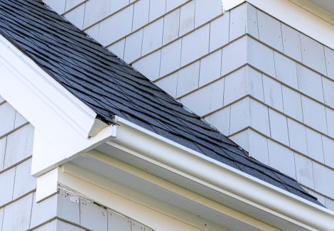Soffits and trim painted white on gray stained shingle home.