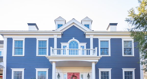 Blue home with white trim and a dark peach door.