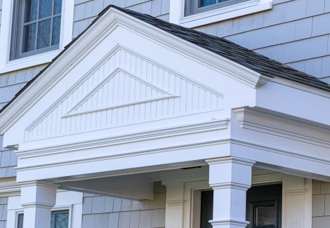 White painted decorative woodwork on front porch of home.