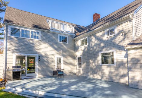 Back porch of cedar shingle home with white painted trim