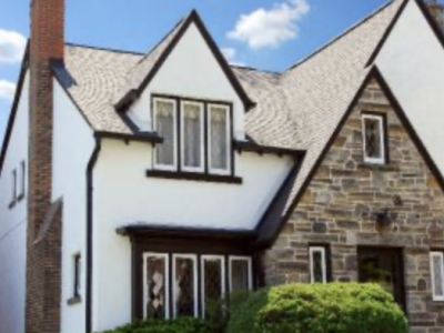 White stucco tudor styole home with dark trim