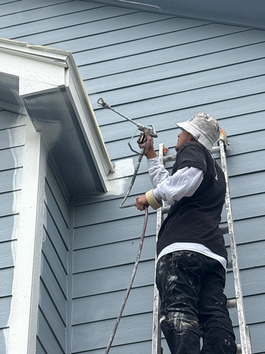 painter spraying siding on house Preview Image 4