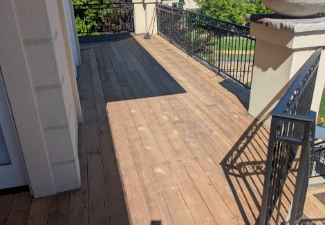 stripped wooden deck with metal railing